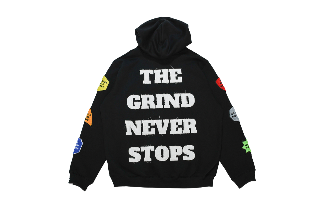 Black hoodie with 'The Grind Never Stops' text on a white background