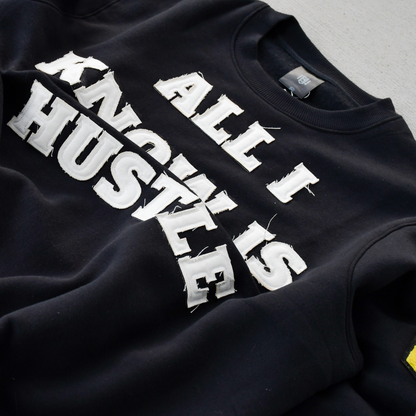 Black sweatshirt with 'All I Hustle Is' text on a gray background